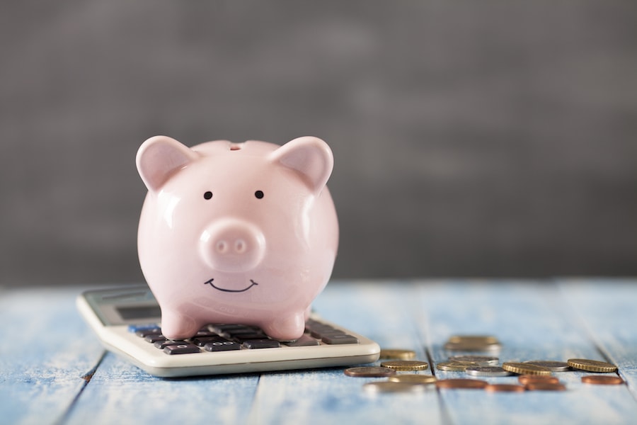 Piggy bank on top of calculator depicting saving money on energy costs.