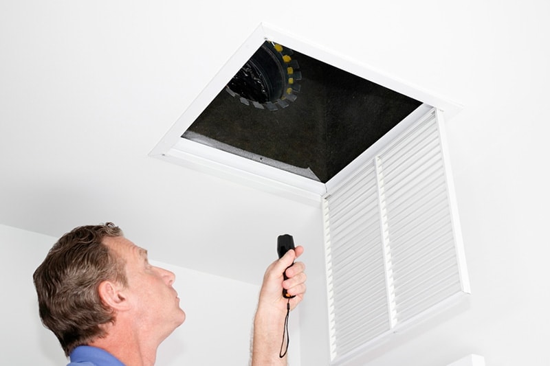 HVAC technician inspection the air ducts in Waco, TX, home.