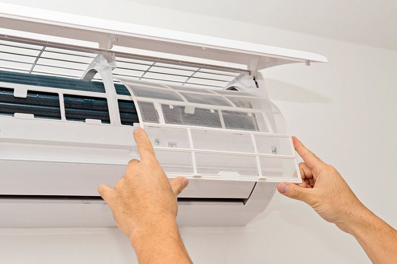 Image of someone replacing a filter inside a ductless system. What Maintenance is Needed for a Ductless System?