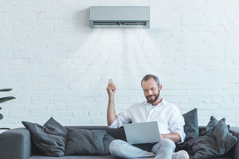 Image of someone sitting below ductless system. Video - 4 Amazing Benefits of Ductless Units.