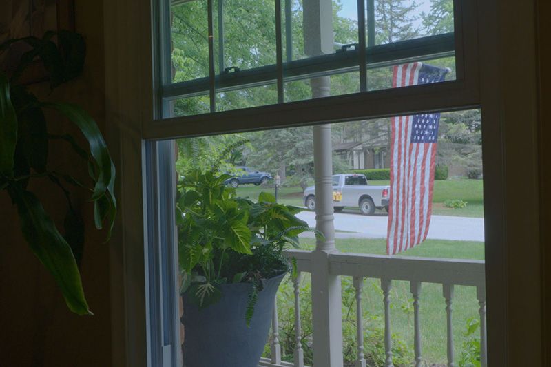 Video - Energy Saving Tip 6. Image is a photograph of an open window looking out at a front yard and the street.