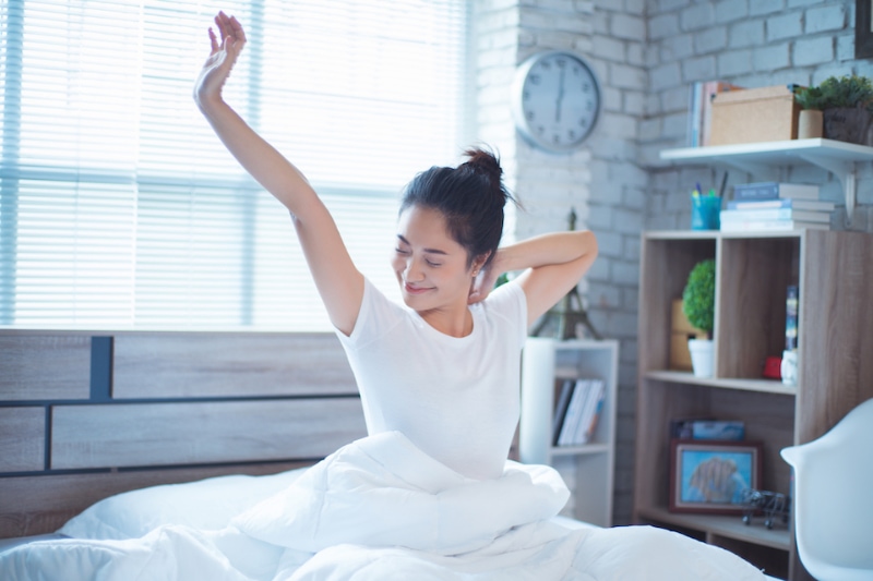 Your HVAC System Can Enhance Sleep - Asian women She is in bed and was waking up in the morning. She felt very refreshed.