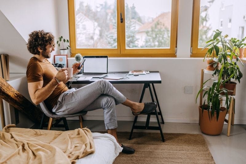 Male homeowner sitting at desk on his phone