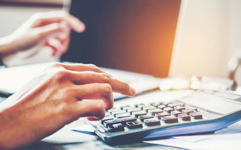 Homeowner crunching numbers to represent potential mistakes when purchasing an air conditioner.