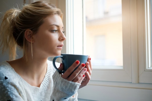 Young woman sitting by window