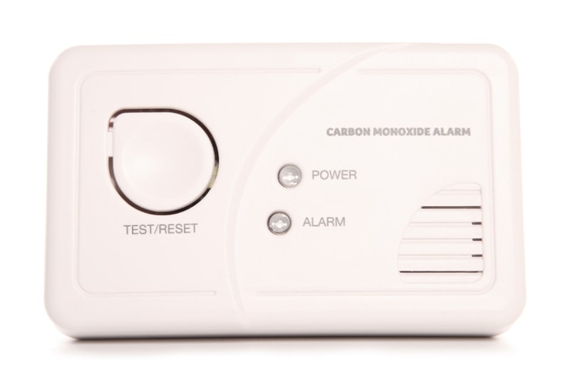Carbon monoxide alarm.|Father teaching child how to water a plant to represent information about carbon monoxide.