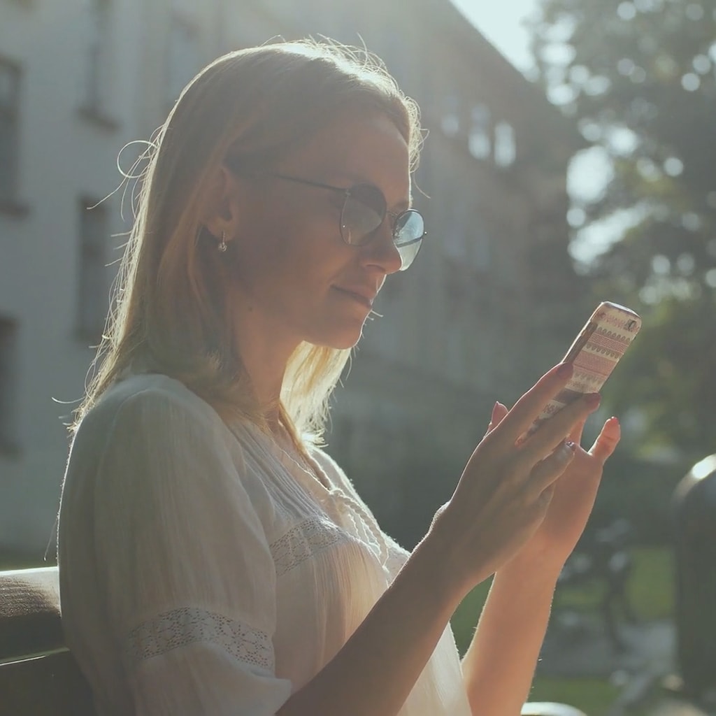 Girl setting her thermostat from smartphone.