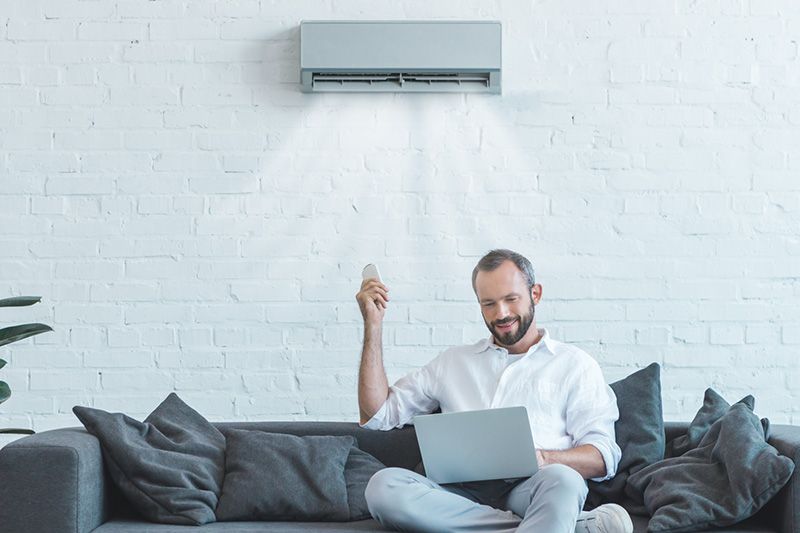 Male homeowner sitting below ductless system. Video - 4 Amazing Benefits of Ductless Units.|Female homeowner sitting below ductless system. Video - 4 Amazing Benefits of Ductless Units.