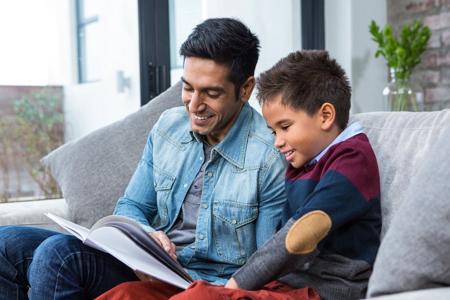 Father reading with son to represent info on improving your indoor air quality this fall.